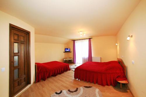 a room with two beds and a window and a door at Pensiunea Sarah Bran in Bran