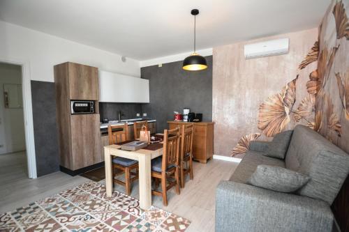 a living room and kitchen with a couch and a table at Sunset Lodge - ENJOY HOLIDAY in Garda