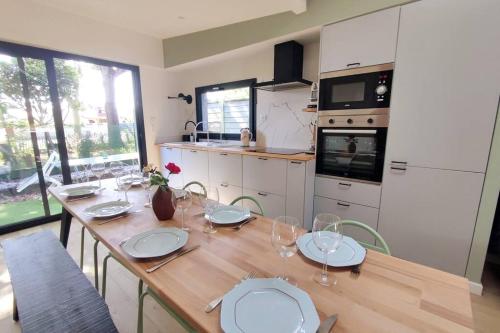 - une cuisine avec une table en bois et des verres à vin dans l'établissement La cabane C70 proche bassin d'arcachon, à Arès