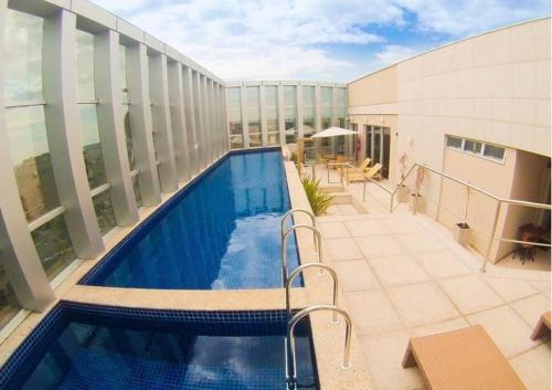 a swimming pool on the balcony of a building at Flat Hotel Fusion + Estacionamento Grátis H05 in Brasilia