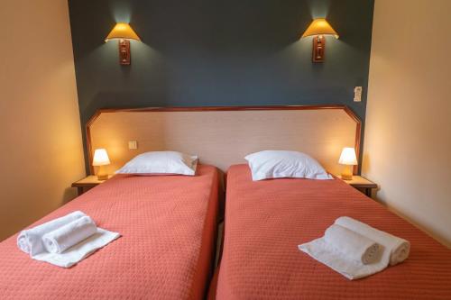two beds in a hotel room with towels on them at Residence Mare e Sole in Taglio-Isolaccio
