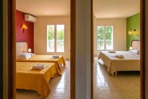 2 bedden in een kamer met 2 bedden, waarvan 1 tweepersoonsbed en 1 eenpersoonsbed. bij Residence Mare e Sole in Taglio-Isolaccio
