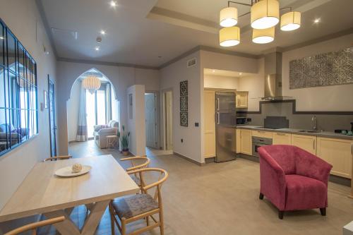 a kitchen and living room with a table and chairs at Apartamentos Turísticos La Baílla in Rota