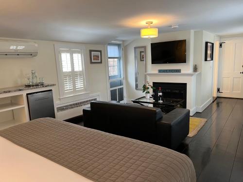 a living room with a couch and a flat screen tv at The Platinum Pebble Boutique Inn - Adults Only Property in Harwich Port