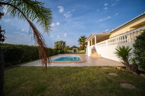 a house with a swimming pool in a yard at A típica casa de férias in Parchal