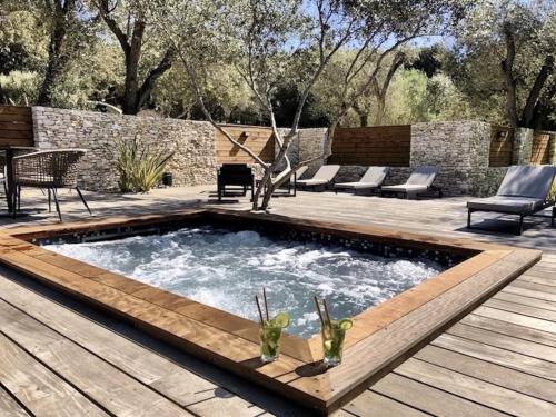 a swimming pool with a wooden deck and a patio at Hôtel E Tre Stelle in Bonifacio