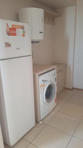 uma cozinha com uma máquina de lavar roupa e um frigorífico em Rainfort Turizm Apart em Denizli