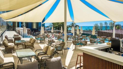 a patio with tables and chairs and umbrellas at Kırbıyık Resort Hotel - Alanya in Kargicak