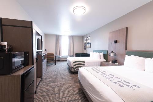 a hotel room with two beds and a flat screen tv at Oxford Suites Paso Robles in Paso Robles