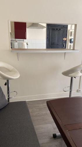 - un salon avec une table et deux tabourets dans l'établissement Comfy Parisian studio!, à Ivry-sur-Seine