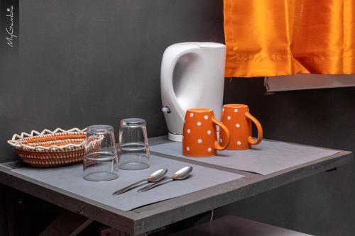 una mesa con tazas y utensilios. en Lovely 13-Bed Complex on Cape Point Beach Bakau - Bojang River Lodge, en Bakau