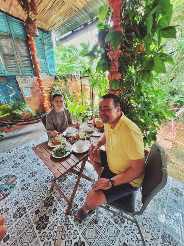 a man and woman sitting at a table eating food at Mekong Pottery Homestay, Green-Friendly & Boat Tour in Vĩnh Long