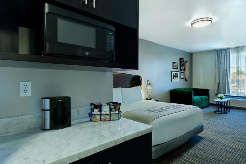 a hotel room with a bed and a flat screen tv at Oxford Suites Paso Robles in Paso Robles