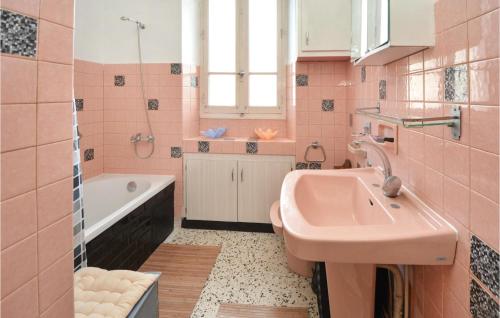 a pink bathroom with a sink and a tub at 2 Bedroom Lovely Apartment In Als in Alès