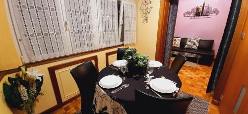 uma sala de jantar com uma mesa com cadeiras pretas em MyHouseSpain - Apartamento 2 habitaciones cerca de la playa em Gijón