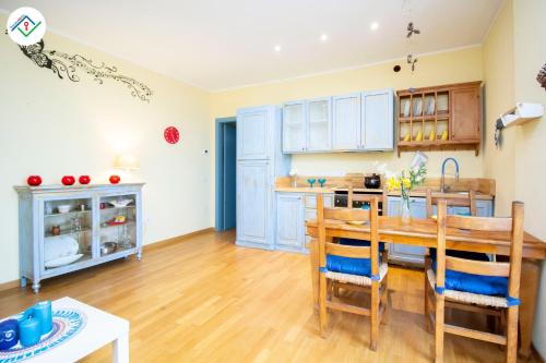 a kitchen with blue cabinets and a wooden table at Vedo il Mare by TuscanyWeGo in Livorno