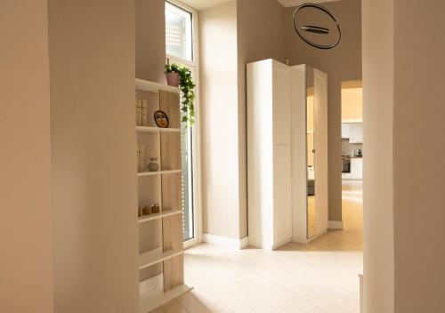 un pasillo con estanterías blancas en una casa en Amedeo Suite - Il salotto di Napoli, en Nápoles