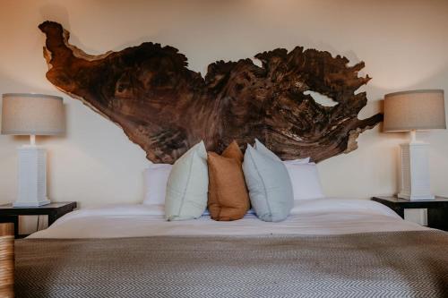 a bedroom with a bed with a tree headboard at Sansara Surf Yoga & Resort in Cambutal