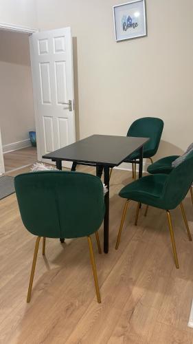 a table and four green chairs in a room at Relax dotcom in Manchester