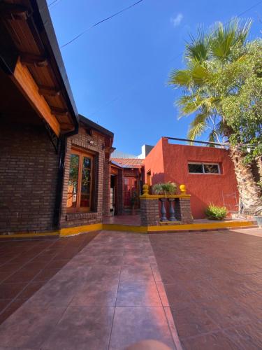 uma casa com uma palmeira em frente em Hostel Ruca Potu em Mendoza
