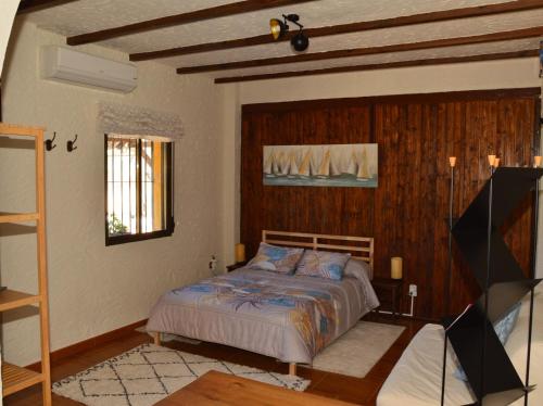 a bedroom with a bed and a flat screen tv at Cortijo Petra in Villanueva del Rosario