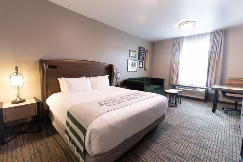 a hotel room with a large bed and a desk at Oxford Suites Paso Robles in Paso Robles