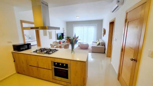 a kitchen with a stove and a living room at Amar'e Aparthotel & Spa in Las Terrenas