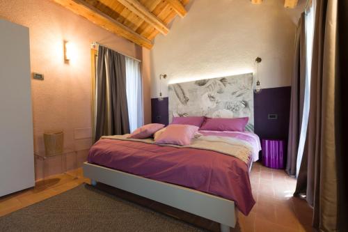 a bedroom with a large bed with pink pillows at Dimora Grotta Azzurra in Tiago