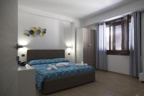 a bedroom with a bed with blue sheets and pillows at B&B Piano di Sopra in San Vito lo Capo