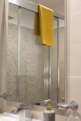 a bathroom mirror with a yellow towel hanging over a sink at B&B Piano di Sopra in San Vito lo Capo