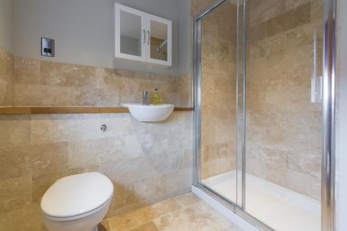 a bathroom with a shower and a toilet and a sink at Caddows in Docking