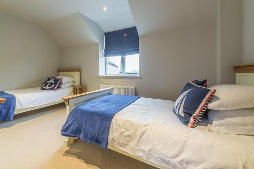 a bedroom with two beds and a window at Caddows in Docking