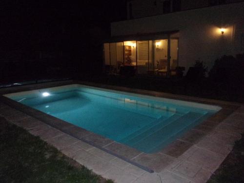 a swimming pool at night in front of a house at Appartement du Pont neuf in Villegailhenc