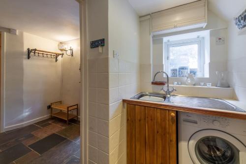 a kitchen with a washing machine and a sink at Columbine Cottage in Holme next the Sea