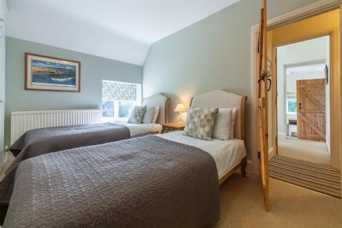 a bedroom with two beds and a window at Columbine Cottage in Holme next the Sea