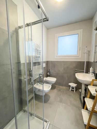 a bathroom with a shower and a toilet and a sink at Sunset Lodge - ENJOY HOLIDAY in Garda