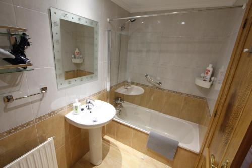 une salle de bains avec lavabo et baignoire dans l'établissement El Rincón del Reloj, à Llanes