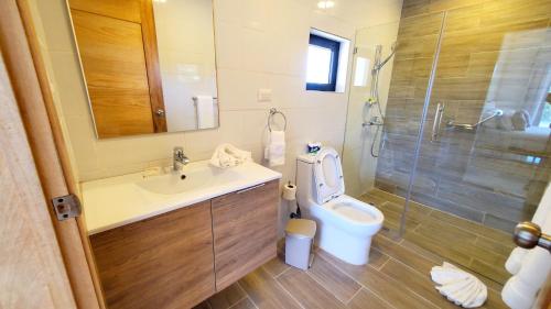 a bathroom with a toilet and a sink and a shower at Amar'e Aparthotel & Spa in Las Terrenas