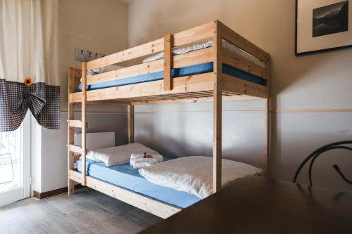 a wooden bunk bed in a room with a table at La Casaregina in Valdieri