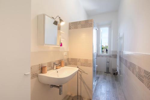 a bathroom with a sink and a mirror and a shower at Piombino Apartments - Casa Collodi in Piombino