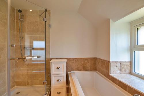 a bathroom with a tub and a glass shower at Finest Retreats - Trethew Cottage in Carnbrea
