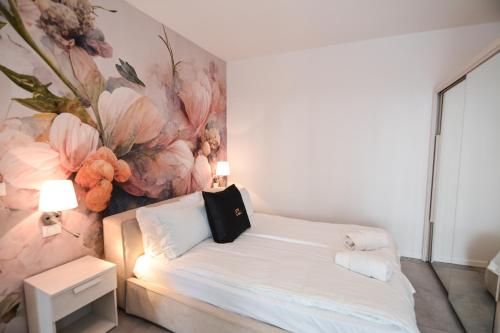 a bedroom with a bed with a flower painting on the wall at Sunset Lodge - ENJOY HOLIDAY in Garda