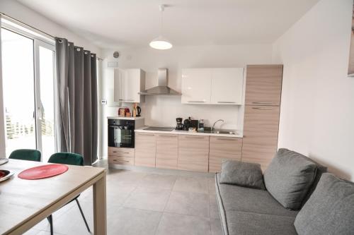 a kitchen and living room with a couch and a table at Sunset Lodge - ENJOY HOLIDAY in Garda