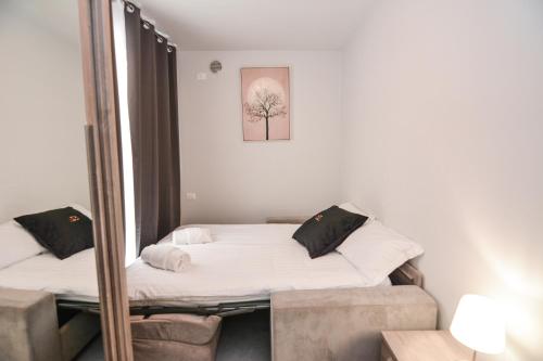 a bedroom with a bed and a mirror at Sunset Lodge - ENJOY HOLIDAY in Garda