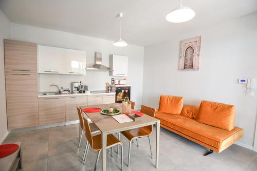 a kitchen and living room with a table and a couch at Sunset Lodge - ENJOY HOLIDAY in Garda