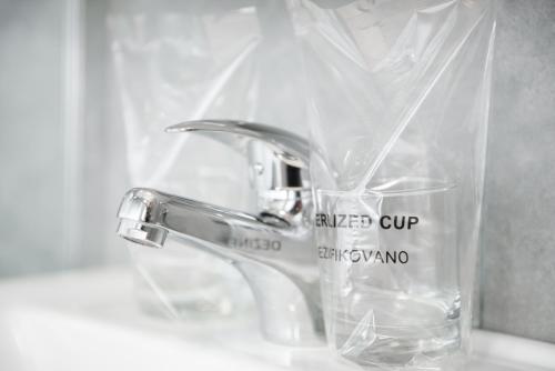 a glass vase sitting next to a bathroom sink at DuMalux Velvet in Subotica