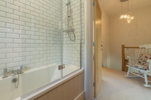 a bathroom with a tub and a walk in shower at Wigeon Cottage in Thornham