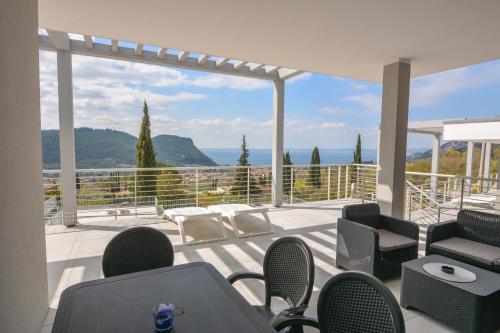 a balcony with chairs and a view of the ocean at Sunset Lodge - ENJOY HOLIDAY in Garda