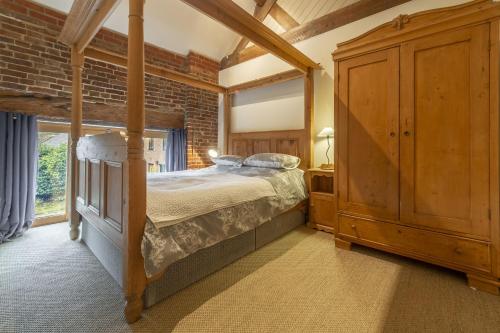 a bedroom with a bed and a large window at Great Barn in Colkirk