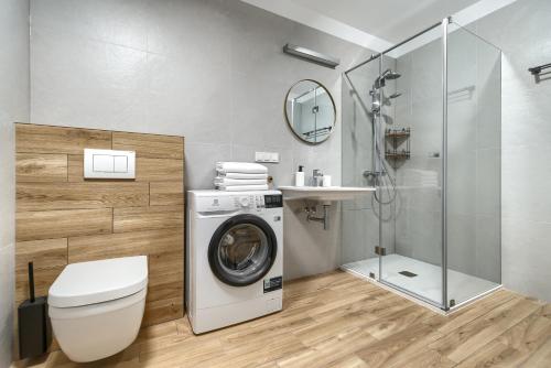 a bathroom with a washing machine and a shower at Apartamenty Solaris in Darłówko